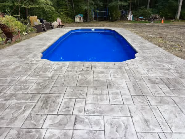 Stamped concrete pool deck surrounding an in-ground pool