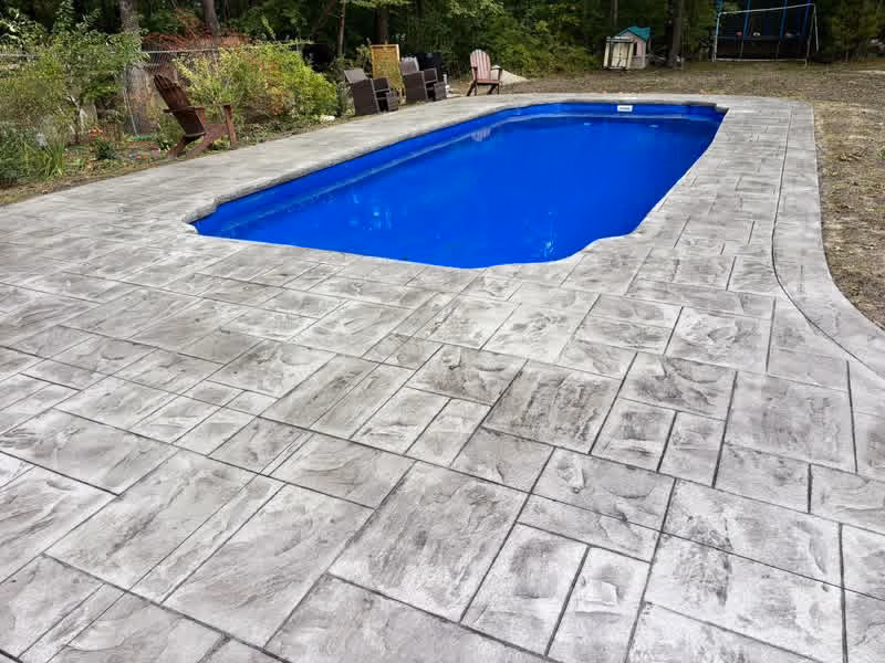Stamped concrete pool deck with a curved walkway