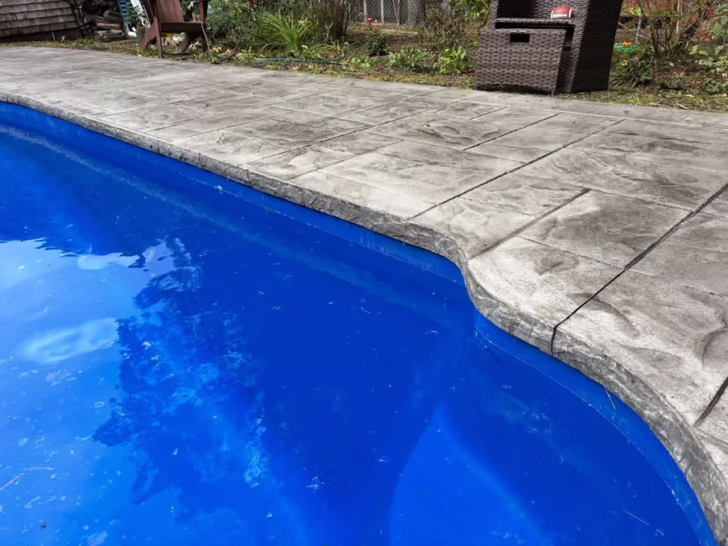 Stamped concrete pool deck edge along the water